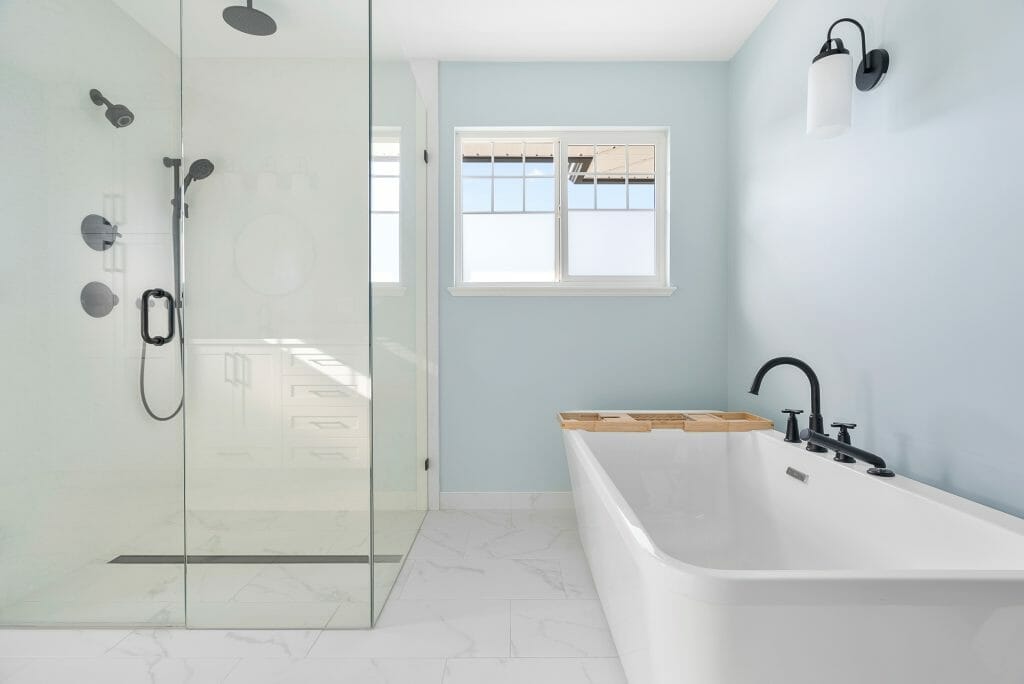 A view from the bathroom doorway showing the walk-in glass shower and large white soaker bathtub.