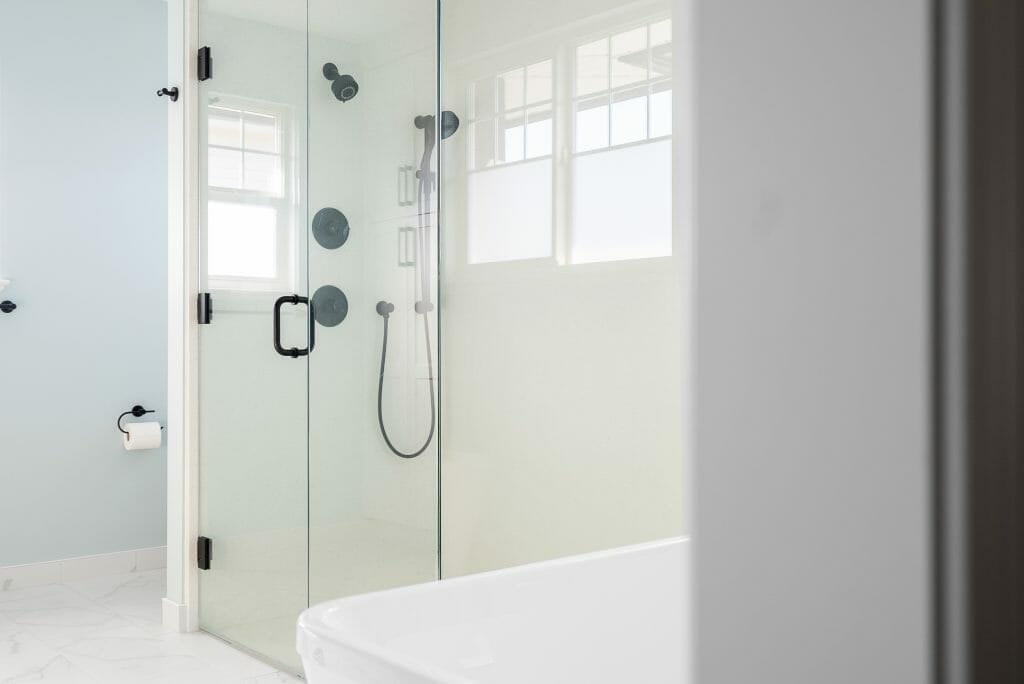 A newly renovated bathroom with a large glass walk-in shower and modern shower fixtures.