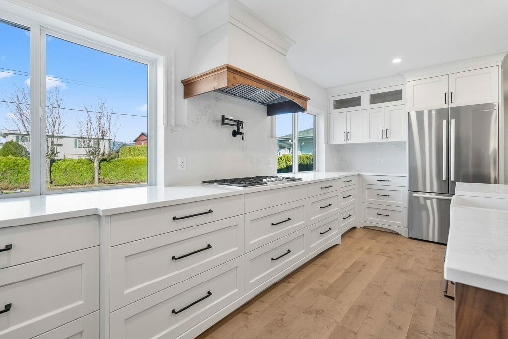 Panoramic view of a new kitchen with white cabinets.