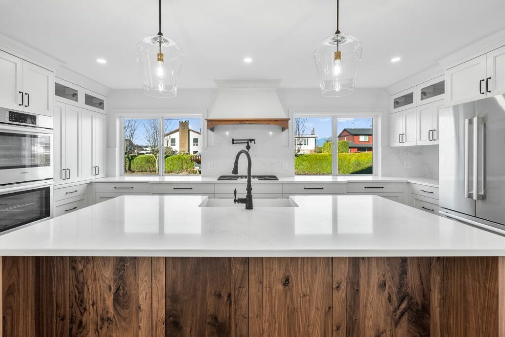 View of a newly renovated white kitchen from in front of a large kitchen island.