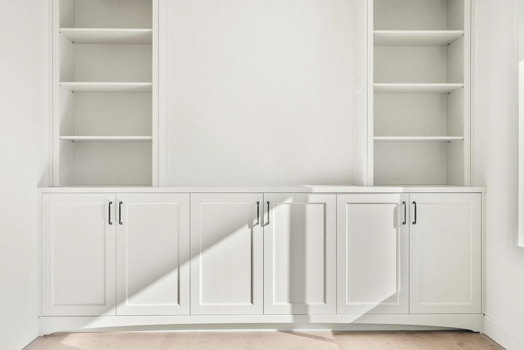 Built-in cabinets and bookshelf at the end wall of a room.