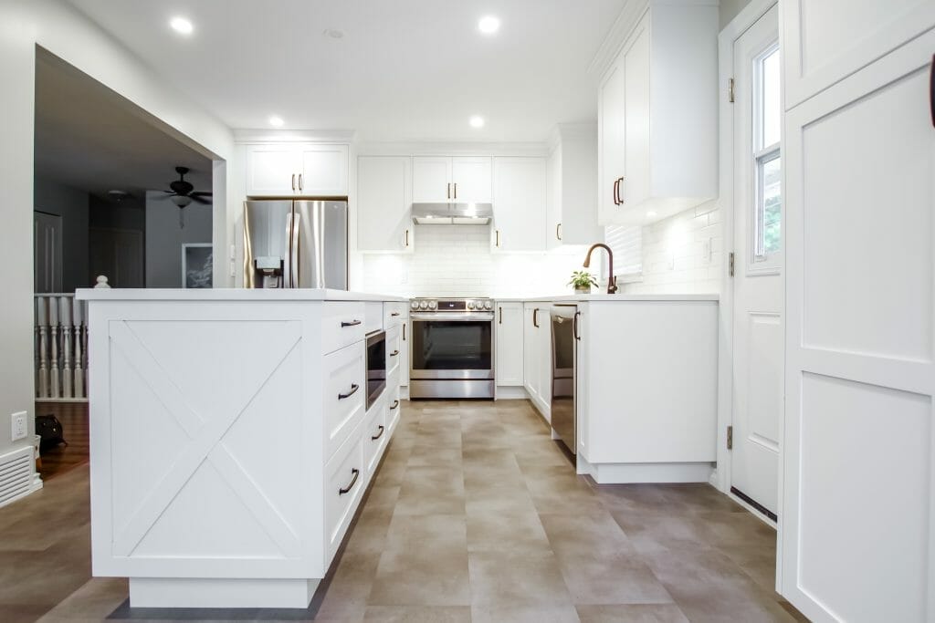 A long renovated kitchen with white cabinets and a very long kitchen island.