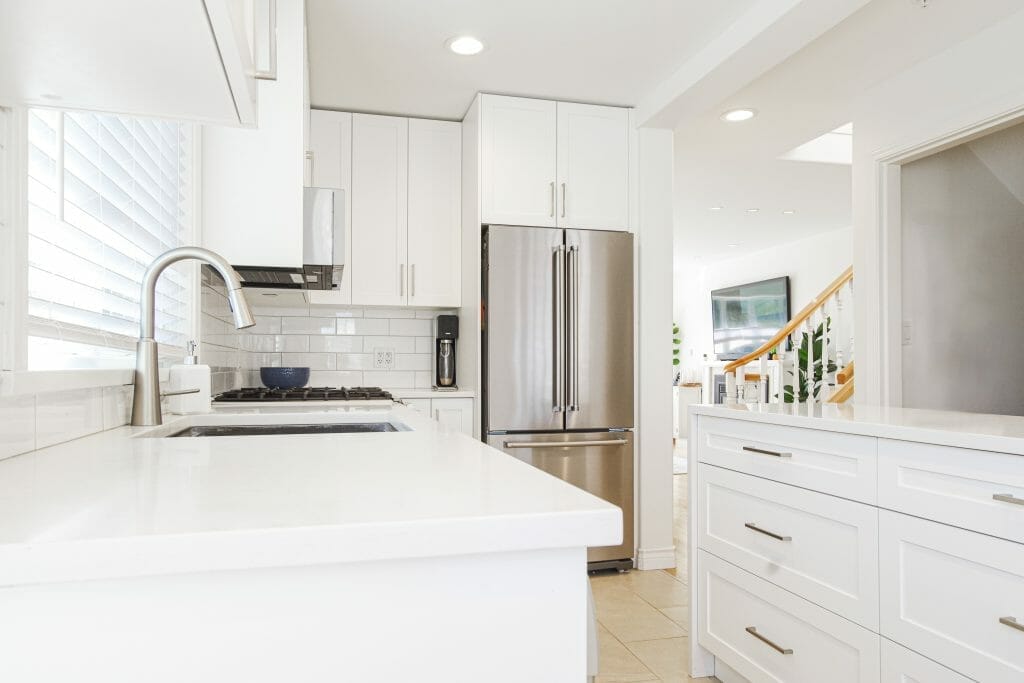 A bright modern kitchen with a large island all in white.